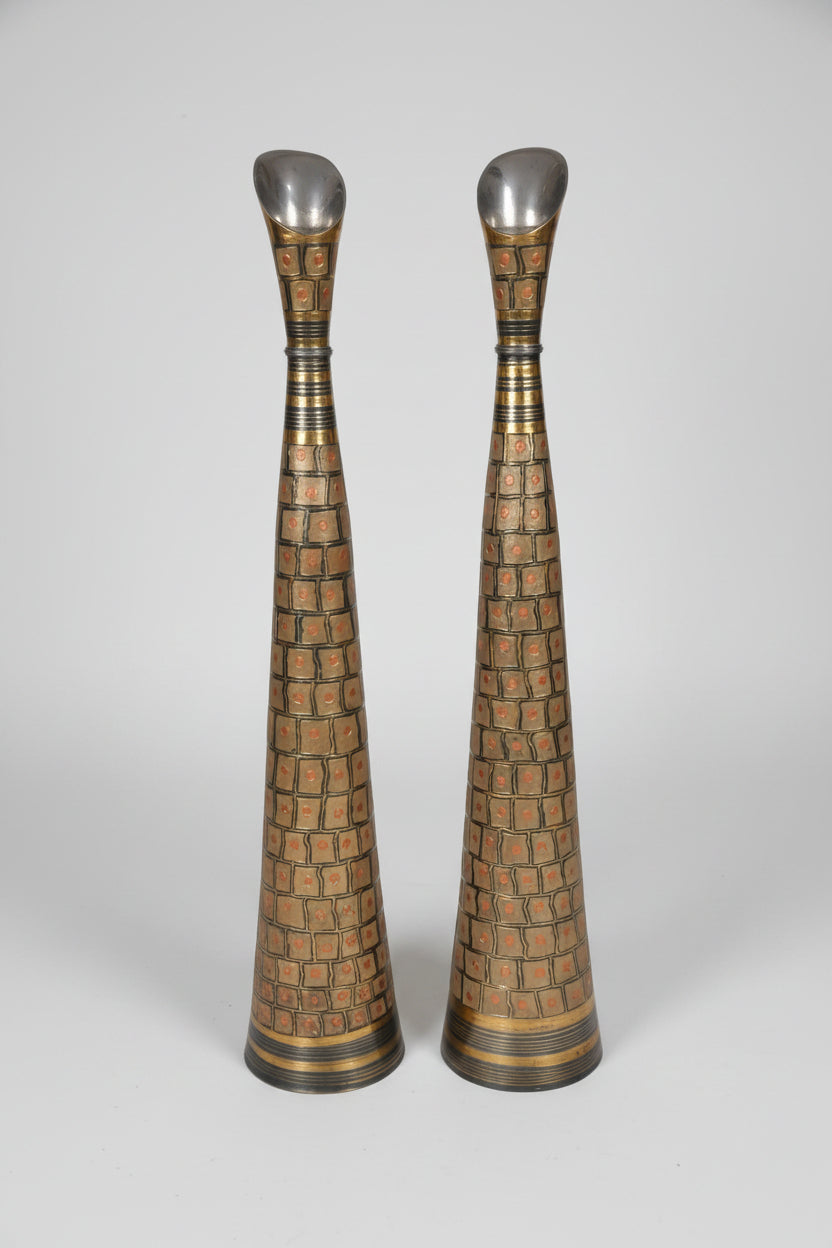 Two tall, decorative vases with intricate patterns on a marble floor.