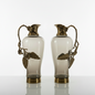 Two ornate vases with gold accents on a white platform, accompanied by a brown leather notebook and gold pens, with 'The Handicraft People' logo in the corner.