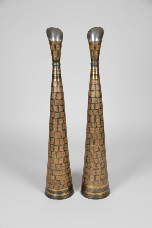 Two tall, decorative vases with intricate patterns on a marble floor.
