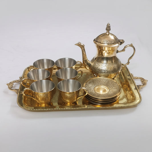 Gold teapot set with cups and tray on a white background